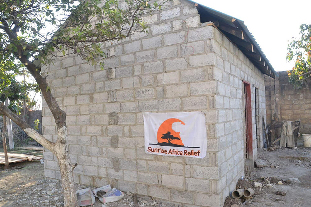 Side view of new toilet block with hanging Sunrise Africa Relief banner