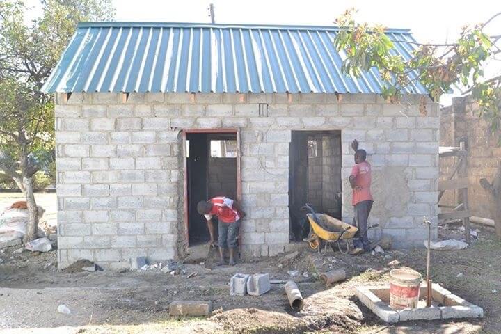 Local contractors working on the toilet block surrounded by building materials