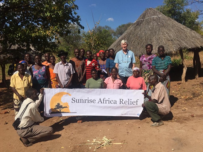 Locals and Robert with Sunrise Africa Relief banner