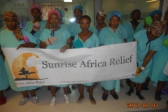 Patients hold the Sunrise Africa Relief banner