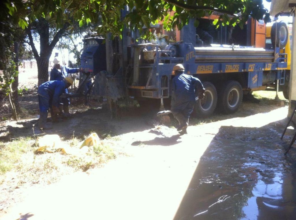 Employees from the drilling company clear the area beside the drilling vehicle