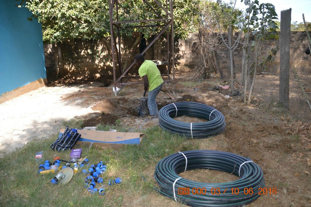Contractor digs beside the borehole surrounded by tubing